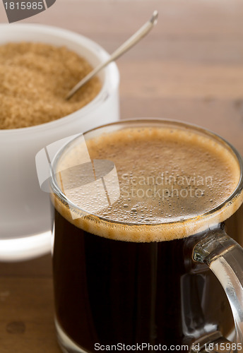 Image of Black coffee and froth in glass mug with sugar