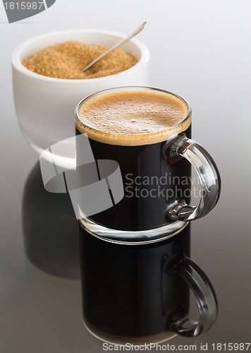 Image of Black coffee and froth in glass mug with sugar