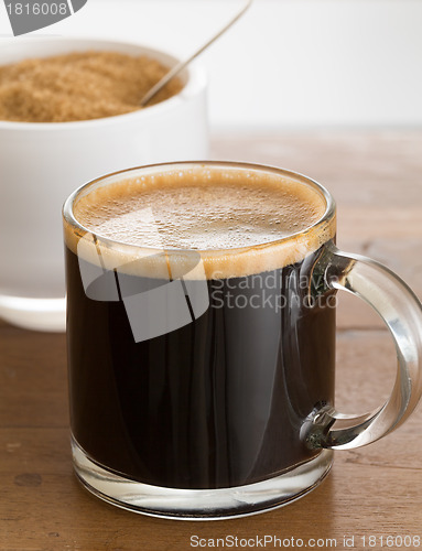 Image of Black coffee and froth in glass mug with sugar