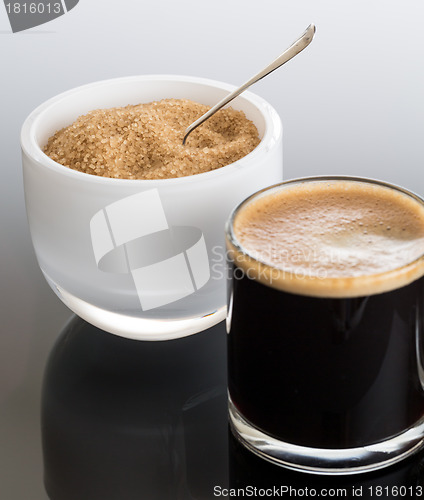 Image of Black coffee and froth in glass mug with sugar