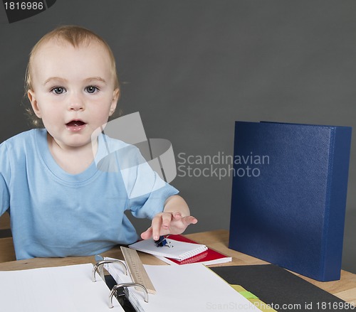 Image of child with paperwork at small desk