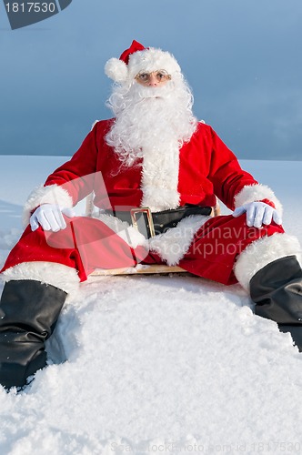 Image of Santa sitting on sunbed in snow