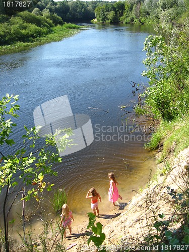 Image of Three little girls plays at the river