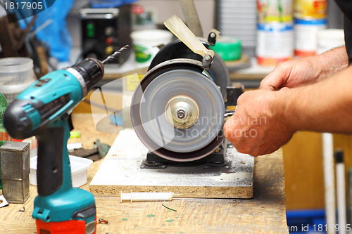 Image of Man working with sharpening machine tool