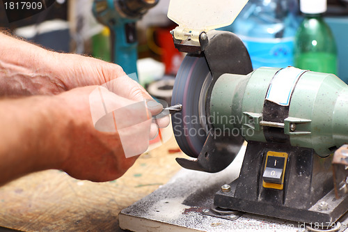 Image of Man working with sharpening machine tool