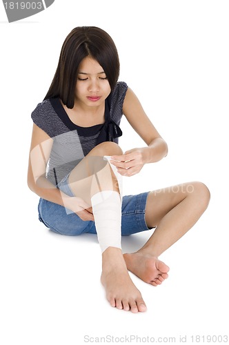 Image of woman wrapping a bandage around her leg