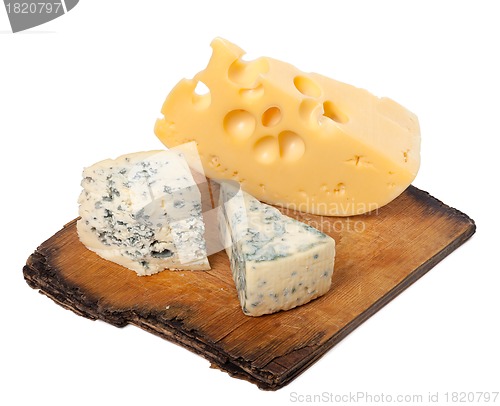 Image of Various types of cheese on old wooden kitchen board