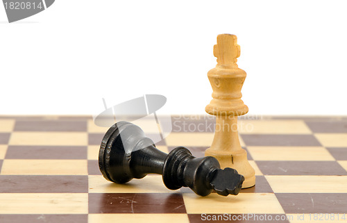 Image of Black chess king lie near winner white legs 