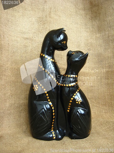 Image of Two toy enamoured cats on a brown background