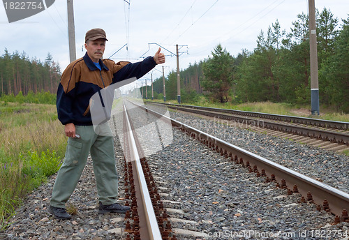 Image of Elderly man on railway with the lifted hand