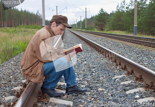 Image of Man sits on railway and with reads 
