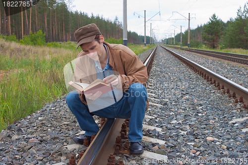 Image of Man sits on railway and with reads 