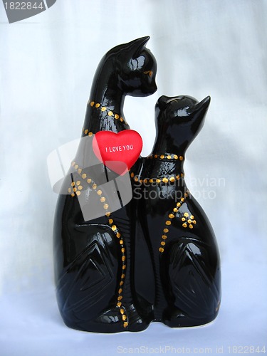 Image of Two toy enamoured cats on a brown background