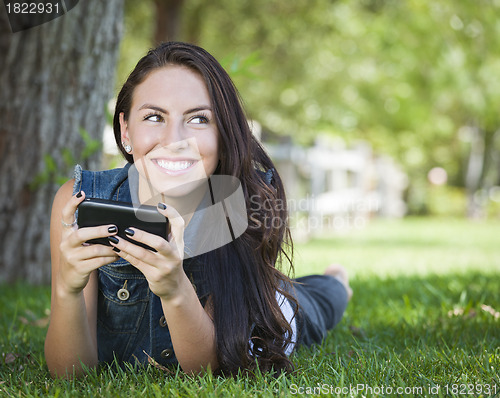 Image of Mixed Race Young Female Texting on Cell Phone Outside