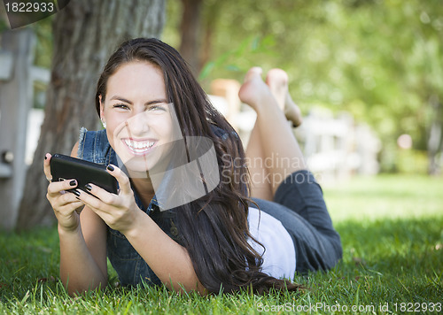 Image of Mixed Race Young Female Texting on Cell Phone Outside