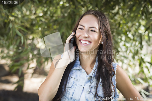 Image of Mixed Race Young Female Talking on Cell Phone Outside