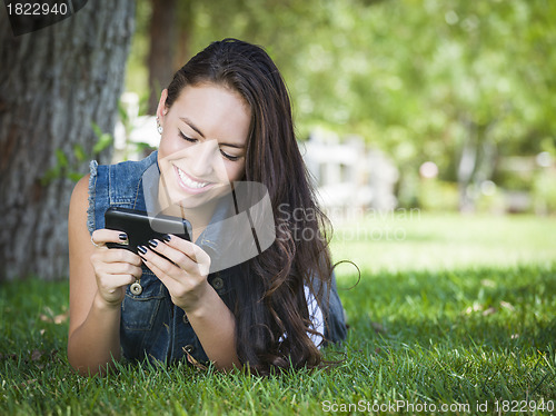 Image of Mixed Race Young Female Texting on Cell Phone Outside