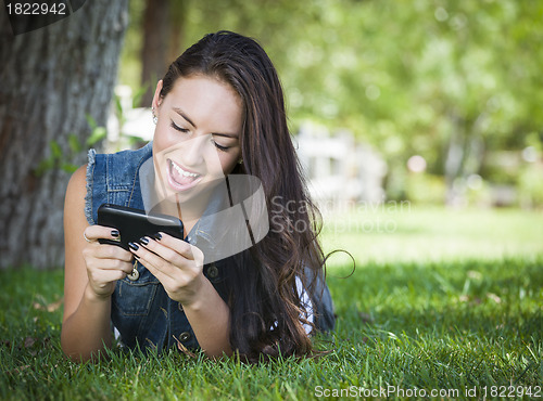 Image of Mixed Race Young Female Texting on Cell Phone Outside