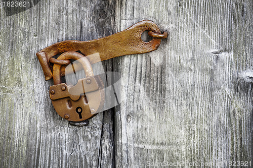Image of Old padlock on a wooden door