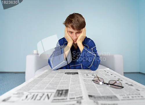 Image of Man with newspaper - hard find a job