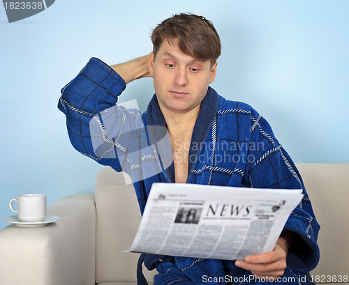 Image of Person reads a newspaper with pensiveness