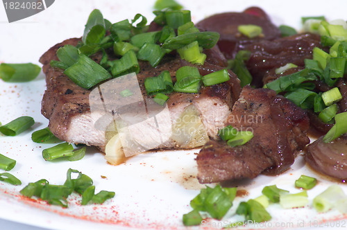 Image of Grilled pork steak on white plate.