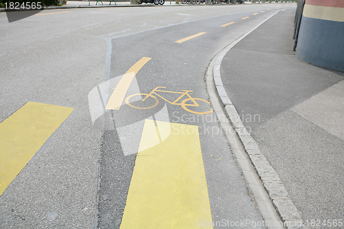 Image of Yellow painted sign for bikes on asphalt 