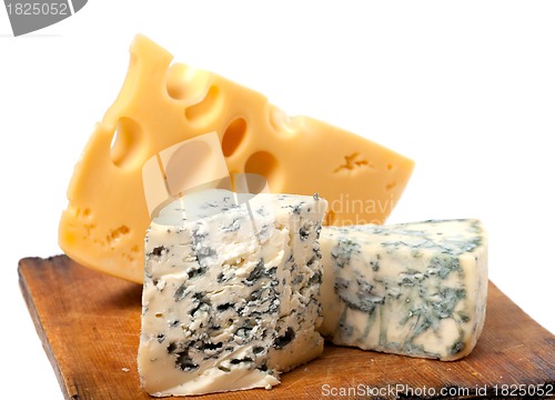 Image of Different types of cheese on wooden kitchen board