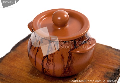Image of Dirty ceramic pot on old wooden kitchen board