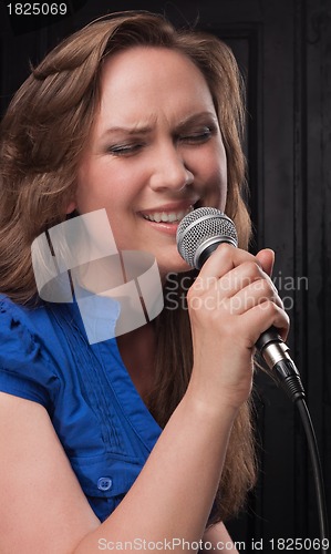 Image of Girl singing to the microphone in a studio