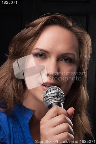 Image of Girl singing to the microphone in a studio