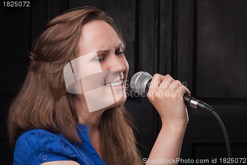 Image of Girl singing to the microphone in a studio