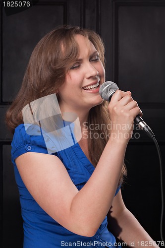 Image of Girl singing to the microphone in a studio