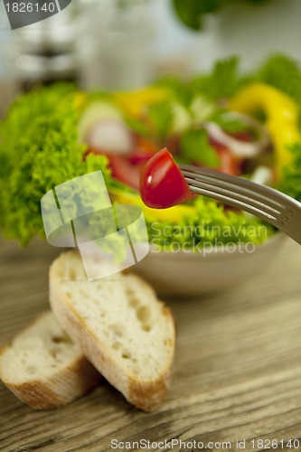 Image of fresh tasty healthy mixed salad and bread on table