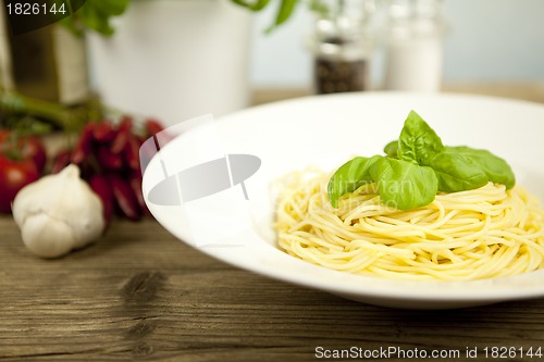 Image of tasty fresh pasta with garlic and basil on table