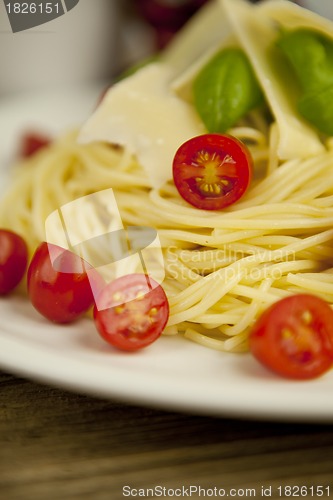 Image of fresh tasty pasta with tomato and basil on table
