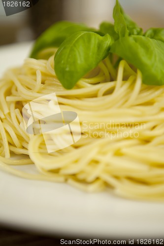 Image of tasty fresh pasta with garlic and basil on table