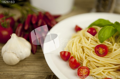 Image of fresh tasty pasta with tomato and basil on table