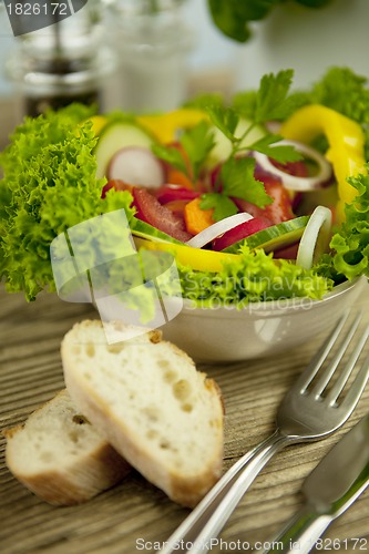 Image of fresh tasty healthy mixed salad and bread on table