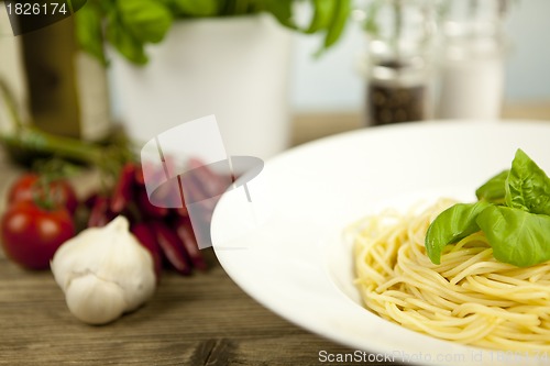 Image of tasty fresh pasta with garlic and basil on table