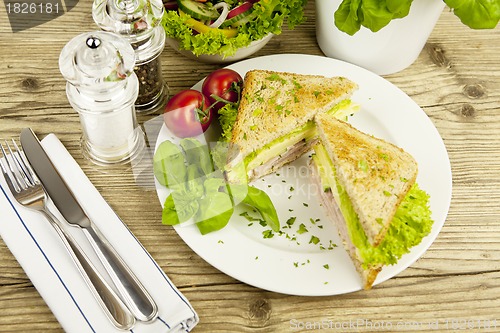 Image of fresh tasty club sandwich with cheese and ham on table
