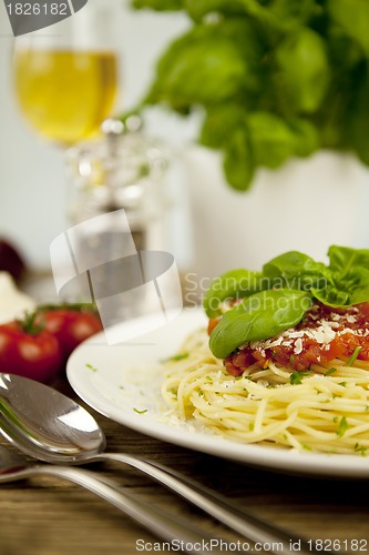 Image of delicious fresh spaghetti with tomato sauce and parmesan on table