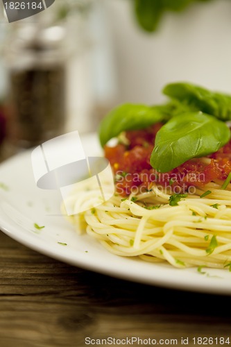 Image of delicious fresh spaghetti with tomato sauce and parmesan on table