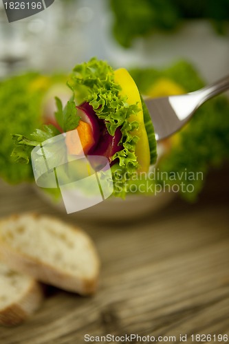 Image of fresh tasty healthy mixed salad and bread on table