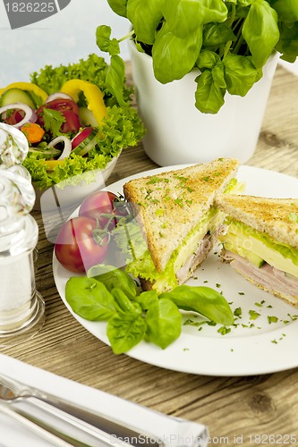 Image of fresh tasty club sandwich with cheese and ham on table