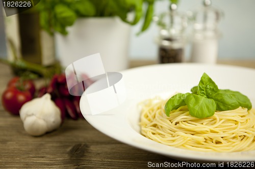 Image of tasty fresh pasta with garlic and basil on table