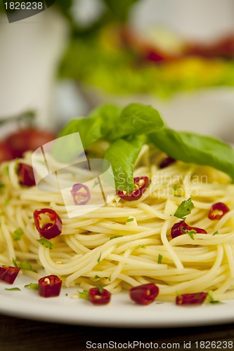 Image of fresh pasta with basil and red chilli on table