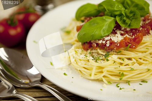 Image of delicious fresh spaghetti with tomato sauce and parmesan on table