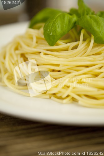 Image of tasty fresh pasta with garlic and basil on table