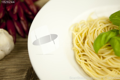 Image of tasty fresh pasta with garlic and basil on table